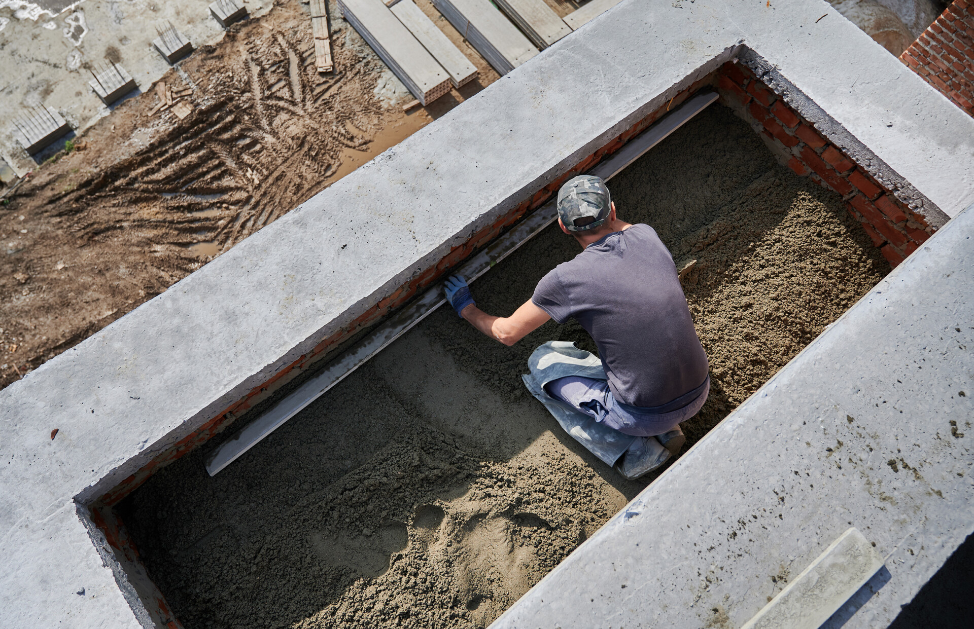 Male worker screeding floor construction site